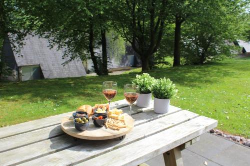 马尔梅迪L'Écureuil - Terrasses de Malmedy的一张野餐桌,上面放有酒杯和食物
