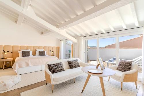 圣特罗佩Villas by Le Yaca Saint-Tropez的一间卧室配有一张床、一张沙发和一张桌子