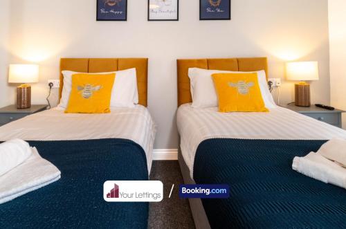 彼得伯勒Luxury 6 Bedroom Contractor House By Your Lettings Short Lets & Serviced Accommodation Peterborough With Free WiFi的两张带橙色枕头的床