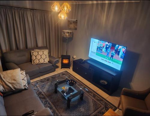 马塞卢Motebong Villa的带沙发和平面电视的客厅