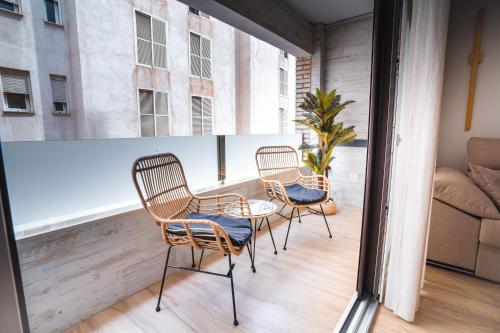 加鲁查Apartamento Boutique Beluga的阳台配有三把椅子、一张桌子和一张沙发