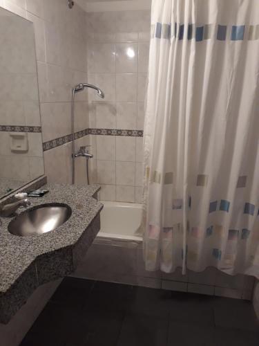 布宜诺斯艾利斯罗马广场酒店的浴室配有水槽、淋浴和浴缸。