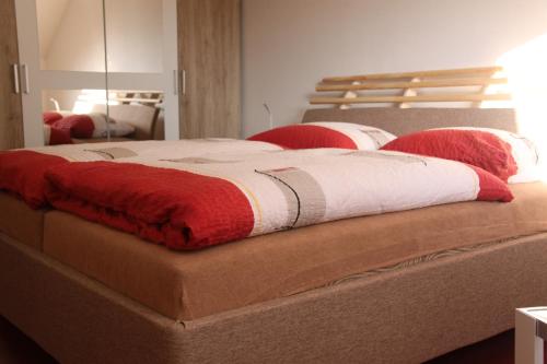 布尔诺科尔波勒旅馆的一张配有红色和白色枕头的大床