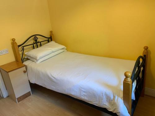 科克Sheraton Lodge Apartments t12e309的卧室配有白色的床和黄色的墙壁
