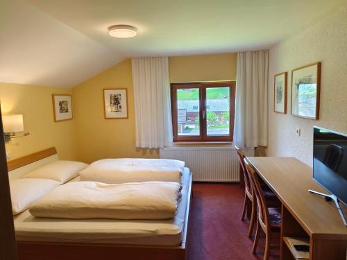 施科佩尔瑙Pension Zita的配有一张床和一张书桌的酒店客房