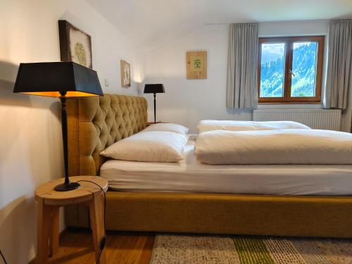施科佩尔瑙Pension Zita的一间卧室设有两张床和一张桌子上的台灯。