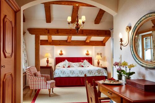 基茨比厄尔Relais & Châteaux Hotel Tennerhof的一间卧室配有红色的床和一张桌子