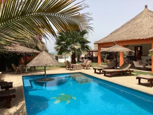 姆布尔Terra Lodge Sénégal的毗邻度假酒店的带椅子和遮阳伞的游泳池