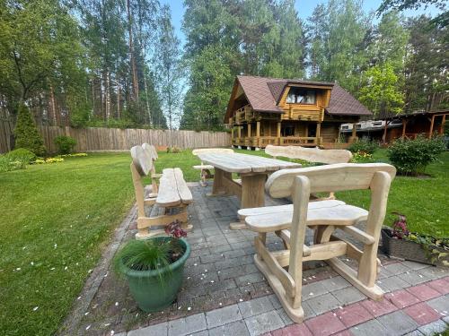 拉脱维亚Guest house Saulainie krasti的房屋前的野餐桌和长凳
