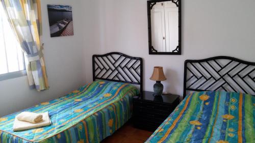 卡亚俄萨尔瓦赫Villa Azul的一间卧室设有两张单人床和一面镜子