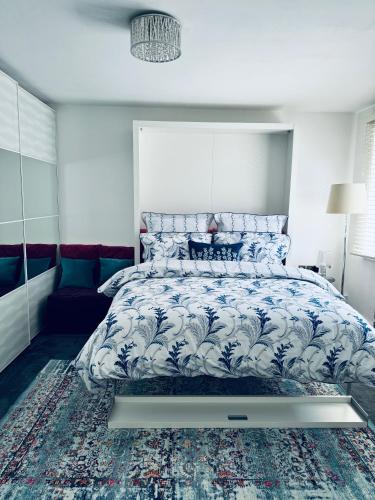 伦敦Central London stylish newly decorated studio flat的一间卧室配有一张带蓝色和白色棉被的床