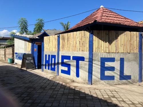 吉利特拉旺安Hostel Gili Trawangan的建筑的侧面是蓝色的文字