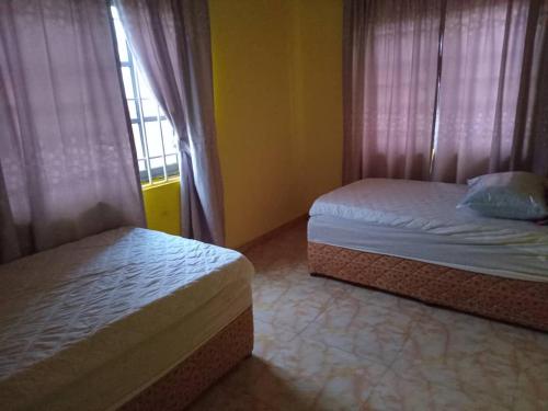 阿克拉Abokobi Cosy Home的一间卧室设有两张床和窗户。