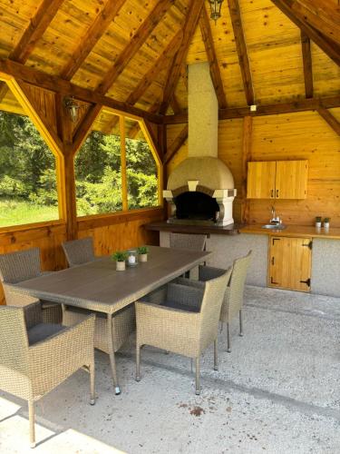 巴伊纳巴什塔Tara Cottage的天井配有桌椅和烤箱。