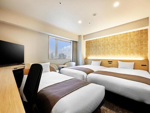 岐阜岐阜大和鲁内酒店的一间酒店客房,设有三张床和一台平面电视
