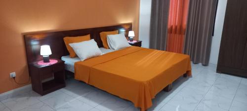 萨尔雷Ka-Bela 2的一间卧室配有一张带两盏灯的大型橙色床