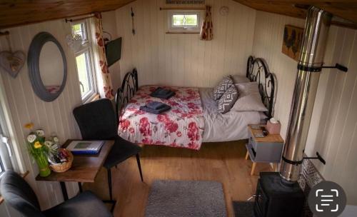 艾尔舍姆Maple Hut Four Acre Farm的一间卧室配有一张床、一张桌子和一张桌子。