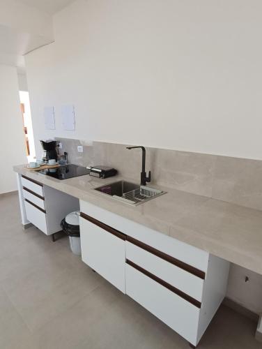 巴拉那州蓬塔尔Residencial Mar Azul-suíte 12的白色的厨房设有水槽和台面