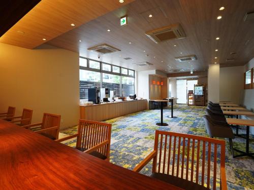 福冈新盖亚官酒店的一间设有长桌子和椅子的等候室