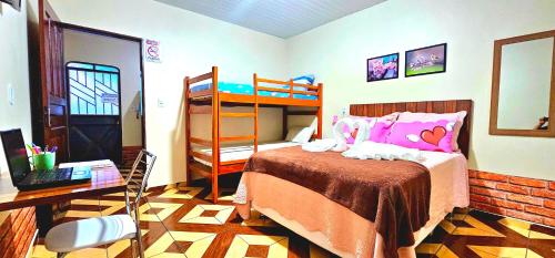 博阿维斯塔Hotel Cida Flats - Apartamento Charmoso com 300 Mbps的一间卧室配有双层床和书桌