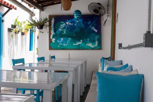 帕拉蒂Casas do Pátio Pousada & Bar的用餐室配有白色的桌子和蓝色的椅子