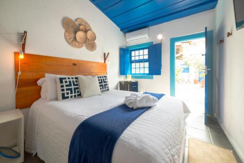 帕拉蒂Casas do Pátio Pousada & Bar的一间卧室设有一张蓝色天花板的大床