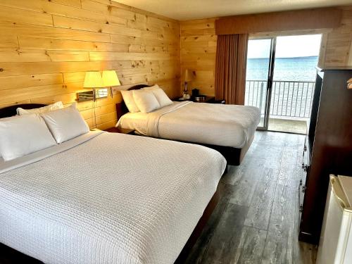 麦基诺城日出海滩汽车旅馆的酒店客房设有两张床和一个阳台。