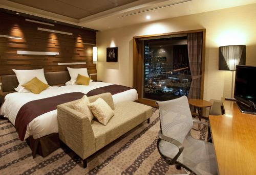 大阪Hotel Granvia Osaka-JR Hotel Group的酒店客房配有一张床、一把椅子和一台电视。