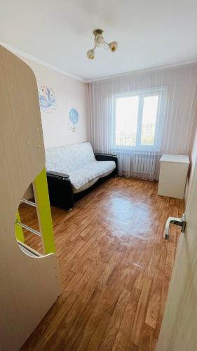 科克舍套Трехкомнатная квартира на Центральном的一间小房间,配有一张床和木地板