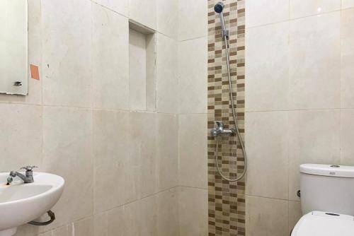 BanjarnegeriUrbanview Hotel Villa Q Gisting的带淋浴、卫生间和盥洗盆的浴室