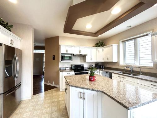 基洛纳Serenity Valley Homestead of Kelowna的厨房配有白色橱柜和不锈钢用具