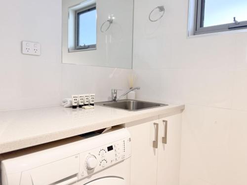 克拉肯巴克Iron Bark Chalet的白色的厨房配有水槽和洗碗机