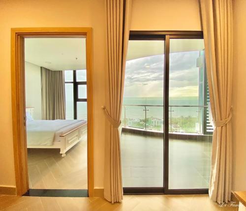 头顿Lfamily Ocean view Apartment 91m2 - ARIA Vung Tau Private Beach Resort, căn hộ Aria Vũng Tàu 91 m2 view biển, bãi biển riêng的一间卧室配有一张床,享有海景