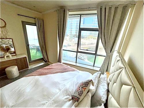 迪拜Wonderful two bed room with full marina view的一间卧室设有一张床和一个大窗户