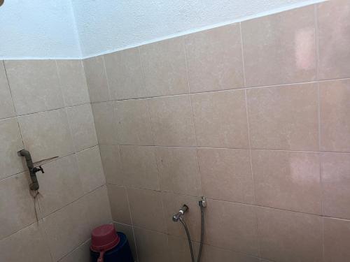 珍南海滩OYO 90981 Chenang Rest House 1的一间带淋浴的浴室和瓷砖墙