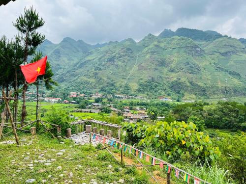 Làng CacDu Già Coffee View Homestay的山丘上的红旗,背景是山丘