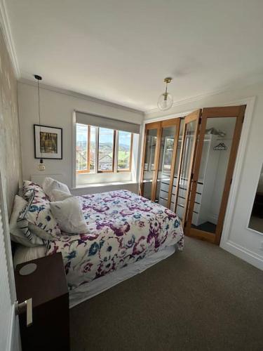 惠灵顿Cosy Coastal Villa in Lyall Bay的一间卧室设有一张床和一个窗口
