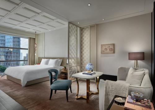 曼谷曼谷瑰丽酒店的一间卧室配有一张床、一张沙发和一张桌子