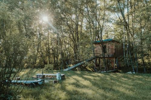 TučapyTreehouse Tučapy的野餐桌和长凳在树木繁茂的田野上