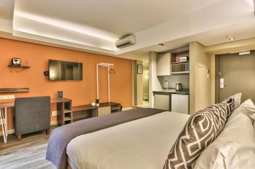 开普敦WINK Aparthotel Foreshore的酒店客房设有一张大床和一个厨房。