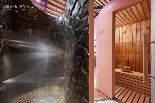 胡志明市Silverland Sil Hotel的浴室配有带石墙的步入式淋浴间