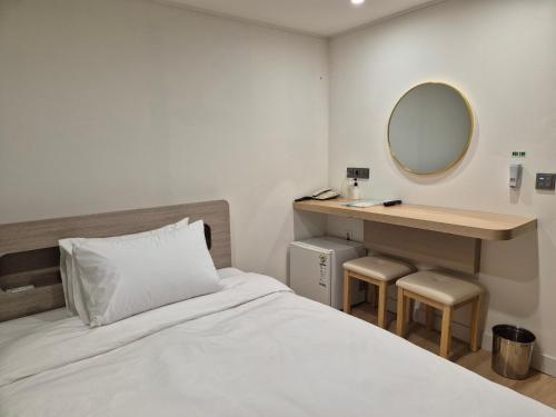 釜山光张酒店的一间卧室配有一张床和一个带镜子的梳妆台