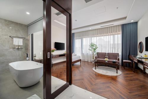 岘港Florence Hotel的带浴缸的浴室和客厅。