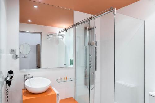 马拉加珀蒂宫广场马拉加酒店的一间带玻璃淋浴和水槽的浴室