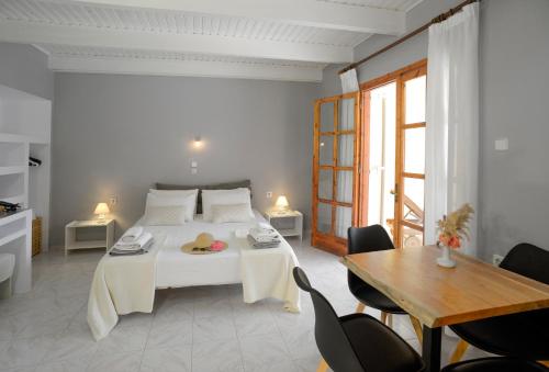 凯特利奥斯阿布罗海滨公寓的卧室配有一张白色的床和桌椅