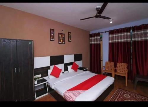 达兰萨拉Mcleodganj Diaries Homestay的一间卧室配有一张带红色枕头的大床