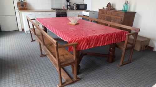 CarnevilleGite du Manoir des Anoteux的一张厨房桌子,上面有红色的桌布