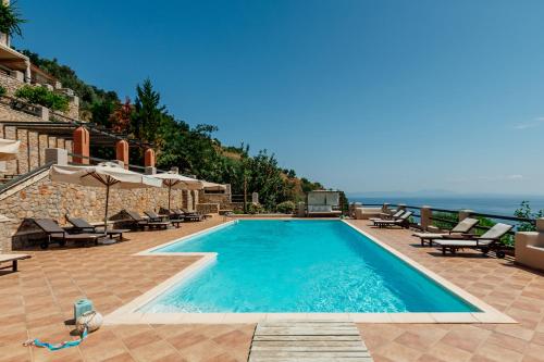 利昂尼迪翁Apelon Tiritas Villas的一个带椅子的游泳池,享有海景