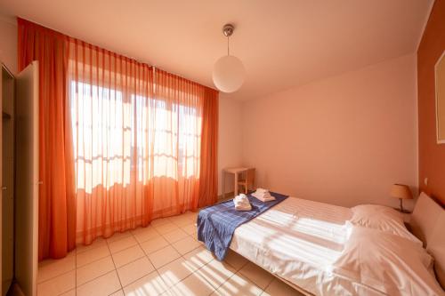 蒂勒尼亚Solidago Residence的一间卧室设有一张床和一个大窗户