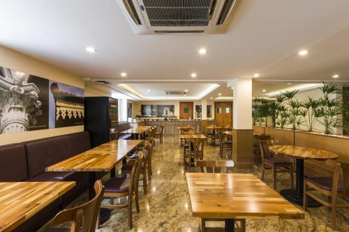 里约热内卢甘博澳里约酒店的配有木桌和椅子的餐厅
